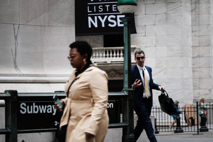 People walk along Wall Street outside the New York Stock Exchange 