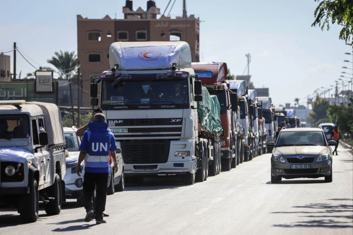 A UN worker walking towards some trucks