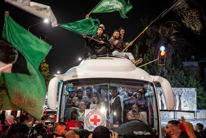 A crowd surrounds a Red Cross bus carrying Palestinians prisoners released from Israeli jails in Ramallah on November 26 2023