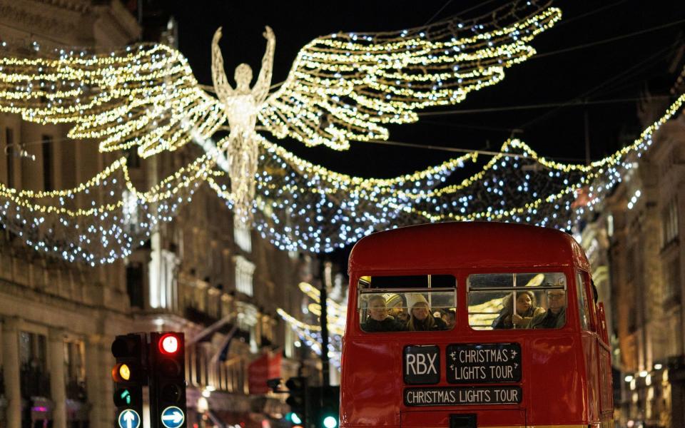 A bus passes under the Christmas lights on Regent Street in London yesterday